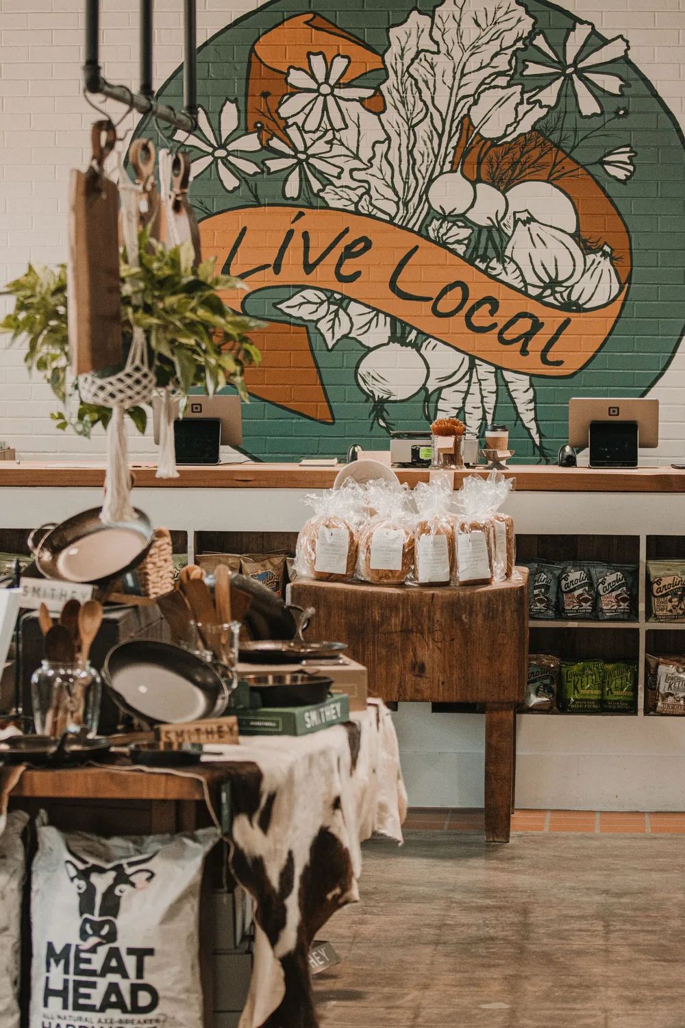 A warm local shop with a hand-painted &ldquo;Live Local&rdquo; mural behind the counter